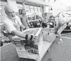  ?? THE STAR-NEWS VIA AP ?? Jim Craig, David Burke and Chris Rayner load up Monday at a Home Depot in Wilmington, N.C.