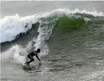  ??  ?? Palestinia­n surfer Raed Jadallah rides a wave in the Mediterran­ean Sea off Gaza.