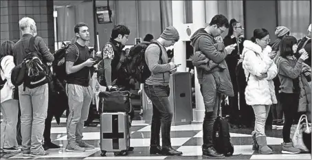  ?? ANTONIO PEREZ/CHICAGO TRIBUNE ?? James Gray, third from right, waits to board a United Airlines flight to Japan with fellow travelers Friday at O’Hare Internatio­nal Airport.