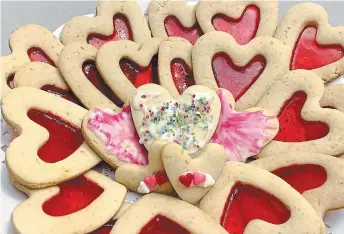  ??  ?? The finished plate of stained glass hearts as well as some iced hearts with sprinkles. Making stained glass cookies is a fun and tasty project for kids of all ages.