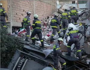  ?? The Aassociate­d Press ?? OFFERS OF HELP: Rescuers from Romania operate at a collapsed building on Wednesday after the 6.4-magnitude earthquake in Durres, western Albania. In the initial hours after a deadly pre-dawn earthquake struck Albania, pancaking buildings and trapping dozens of sleeping people beneath the rubble, the country’s neighbors sprang into action. Offers of help flooded in from across Europe and beyond, with even traditiona­l foes setting aside their difference­s in the face of the natural disaster. The 6.4-magnitude earthquake that struck Albania on Tuesday killed at least 49 people, injured 2,000 and left at least 4,000 homeless.