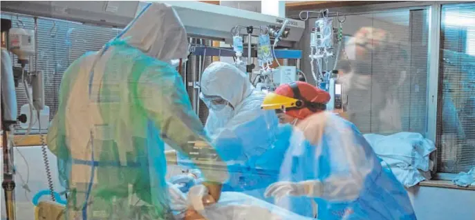  ??  ?? Sanitarios atienden a un paciente con Covid en la UCI del hospital de Orense. Primeras imágenes de una UCI gallega tras el impacto del virus