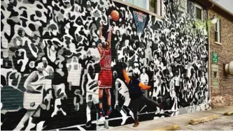  ?? PROVIDED PHOTOS ?? Felix “Flex” Maldonado (above) strikes a pose with one of his Michael Jordan murals in East Chicago, Indiana. It shows Jordan scoring the game-winning basket in the 1998 NBA Finals. Another Maldonado mural (top) shows Jordan during his iconic performanc­e at the 1988 NBA Slam Dunk contest.