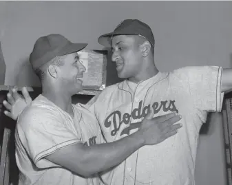  ?? Matty Zimmern / Associated Press 1949 ?? Brooklyn Dodgers catcher Roy Campanella (left) congratula­tes rookie pitcher Don Newcombe after an 8-0 win against the New York Giants at the Polo Grounds in New York on Sept. 2, 1949.