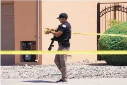  ??  ?? ABOVE: An Albuquerqu­e police officer rolls crime tape after a shooting Thursday afternoon in the parking lot of a private Christian school left one person injured.