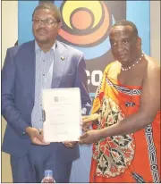  ?? (Courtesy pics) ?? The ESCCOM chief executive giving Channel YemaSwati Director Qhawe Mamba the renewed commercial television broadcasti­ng services licence.