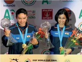  ??  ?? Jitu Rai and Heena Sidhu pose with their gold medals and trophies in the 10m air pistol mixed team event of the ISSF World Cup Final at the Karni Singh ranges in New Delhi on Tuesday.