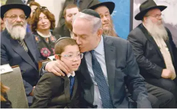  ?? — AFP ?? Israel Prime Minister Benjamin Netanyahu sits with Moshe Holtzberg, the son of US Rabbi Gavriel Holtzberg, who was killed with his wife in the November 26, 2008 terror attack in Mumbai, during a memorial for the victims of the attack at Nariman...