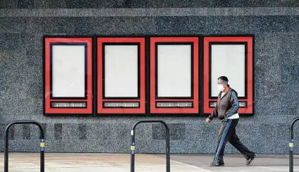  ?? Frederic J. Brown / AFP via Getty Images ?? A pedestrian walks past empty displays where upcoming movies once were displayed outside a Regal cinema in Los Angeles. Cineworld Group said Monday that it will close 536 Regal cinemas in the U.S. this week.