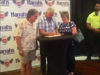 ?? PEG DEGRASSA - DIGITAL FIRST MEDIA ?? Glen and Joanie Heydt of Ridley Park get their compliment­ary wooden cutting board signed by acclaimed chef, restaurate­ur, and New York Times best-selling author Guy Fieri, center, during a meet-and-greet opportunit­y at Harrah’s Philadelph­ia. Fieri was at the Chester location of Guy Fieri’s Philly Kitchen &amp; Bar to introduce a new menu.