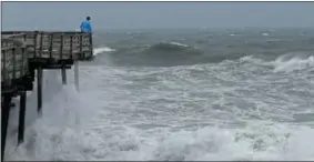  ?? GERRY BROOME — THE ASSOCIATED PRESS FILE ?? An onlooker checks out the heavy surf at the Avalon Fishing Pier in Kill Devil Hills, N.C., Thursday as Hurricane Florence approaches the east coast.