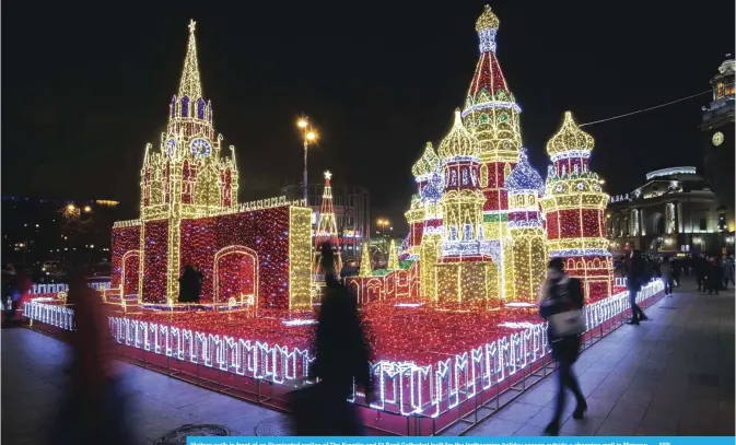  ?? — AFP ?? Visitors walk in front of an illuminate­d replica of The Kremlin and St Basil Cathedral built for the forthcomin­g holiday season outside a shopping mall in Moscow.