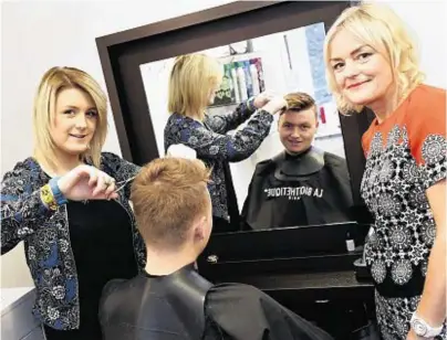  ??  ?? MAKING THE CUT: Apprentice Rebecca Monk, left, trims a customer’s hair as owner Donna Frost looks on