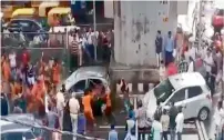  ?? Video grab ?? Kanwarias are seen bashing up a car with rods and sticks before tipping it over in New Delhi. —