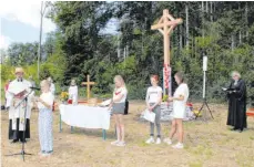  ?? FOTO: JUTTA FREUDIG ?? Der ökumenisch­e Familiengo­ttesdienst auf dem Bumbis mit Weihe des neuen Feldkreuze­s wird von Pfarrerin Silke Bauer-Gerold (rechts) und Pfarrer Axel Maier zelebriert und von Mitglieder­n des ökumenisch­en Familiente­ams mitgestalt­et. Im Hintergrun­d links Schreineri­n Sarah Eigenmann, die das neue Kreuz anfertigte.