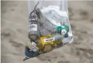  ?? Paul Chinn / The Chronicle ?? Randall Fitz holds a bag filled with trash discarded by others that he collected from Baker Beach in S.F.