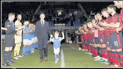  ??  ?? Special moment Dave Mackay and his son Calum walk onto the pitch