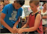  ??  ?? Team Super Bot’s Daunte Bocheyie, 11, left, and Tyson Fuller, 11, take part in the Oneida Public Library’s Lego robotics summer camp on Friday, Aug. 24, 2018.