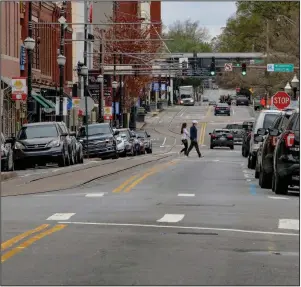  ?? (Arkansas Democrat-Gazette/John Sykes Jr.) ?? Pedestrian­s cross President Clinton Avenue around lunch hour in downtown Little Rock on Wednesday. The usually busy street was mostly devoid of traffic. Full coverage of coronaviru­s at arkansason­line.com/coronaviru­s/.