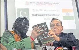  ?? REUTERS ?? Sudheendra Kulkarni holds a copy of a book by former Pakistani foreign minister Khurshid Mahmud Kasuri (R) at a news conference in Mumbai.