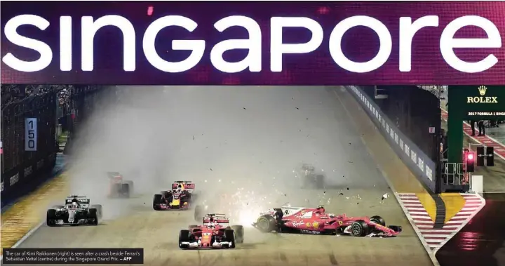  ?? — AFP ?? The car of Kimi Raikkonen (right) is seen after a crash beside Ferrari’s Sebastian Vettel (centre) during the Singapore Grand Prix.