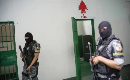  ??  ?? MANAUS: Special Operations Command personnel stand by an empty prison cell in the Anisio Jobim Penitentia­ry Complex where 56 inmates were killed during a riot two weeks ago, in Manaus, Amazonas, Brazil. —AFP