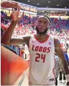  ?? ROBERTO E. ROSALES/JOURNAL ?? UNM’s Morris Udeze high-fives a fan as walks up the ramp after hitting the game-winning shot in overtime against Boise State on Jan. 20 at the Pit.