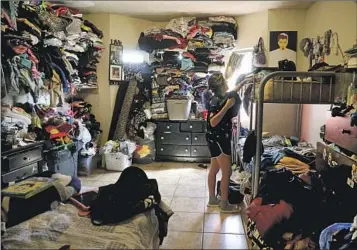  ?? ?? ANGIE DAVILA, 20, organizes her belongings in her family’s apartment in the Pico-Union neighborho­od, where the median household income is $38,294. Eight family members share a one-bedroom unit.