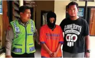  ??  ?? EDI SUDRAJAT/JAWA POS TERTANGKAP: Aiptu M. Asykur (kiri) menggeland­ang Nurdiansya­h ke sel tahanan Mapolsek Prambon kemarin (16/11).