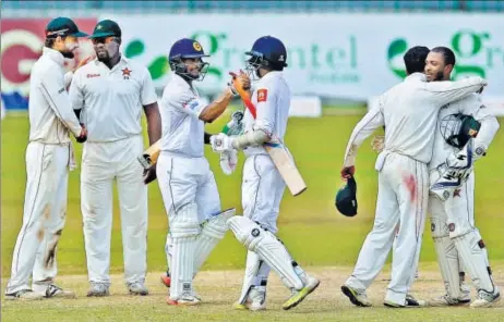  ?? AP ?? Sri Lanka's Dilruwan Perera (third from right) and Asela Gunaratne celebrate their 4wicket victory in the oneoff Test against Zimbabwe in Colombo on Tuesday.