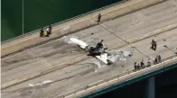  ?? The Associated Press ?? ■ This photo provided by WSVN-TV emergency personnel respond to a small plane crash in Miami on Saturday. The small plane crashed on a bridge near Miami, striking an SUV and bursting into flames.