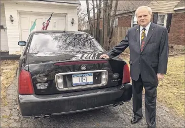  ??  ?? Above, Larry Quinn outside his Troy home, with his personaliz­ed license plate. At left, Quinn going through some of the music he has recordied in his home office.