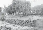  ?? Justin Sullivan / Getty Images ?? Floodwater­s flow over a street during a recordbrea­king rainstorm Monday in Santa Clarita, Calif., just northwest of Los Angeles.