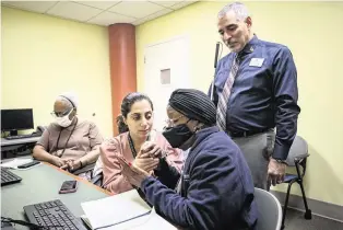  ?? SYDNEY WALSH swalsh@miamiheral­d.com ?? Jorge Hernandez, standing, watches as technology instructor Mirna Garcia, center, teaches Gwendolyn Love, right, and Emma Tyler (left) at the Miami Lighthouse Center for the Blind and Visually Impaired. The nonprofit is helping adults develop digital skills.