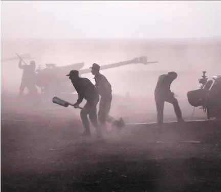  ?? ALEXANDER KOTS/ THE ASSOCIATED PRESS ?? Syrian army personnel load howitzers near the village of Morek. Despite Russian airstrikes that the Kremlin insists are targeting extremists, ISIL was able to make their most significan­t gains in months, increasing their territory close to city of...