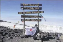  ??  ?? Dr. Dharmesh Patel holds up his American Heart Associatio­n flag after reaching the summit of Mt. Kilimanjar­o.