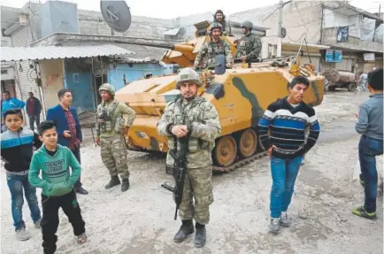  ?? Lefteris Pitarakis, The Associated Press ?? Turkish soldiers secure the streets of the northweste­rn city of Afrin, Syria, in March. Turkey is growing long-term roots in its northern Syrian enclave, nearly two years after its troops moved in.