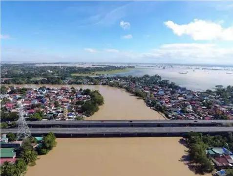  ?? (Apalit LGU) ?? SWOLLEN RIVER. An estimated P118.28 million damage in agricultur­e was reported in the province, as several towns and cities remain flooded due to swollen rivers and the southwest monsoon enhanced by Typhoon Fabian.