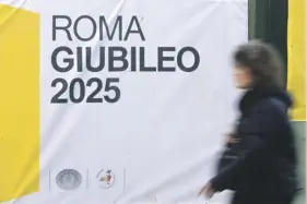  ?? ?? A woman walks past a banner reading ‘Rome-Jubilee 2025’ at the constructi­on site of Piazza Pia in Rome, on March 12. PHOTO: TIZIANA FABI/AFP