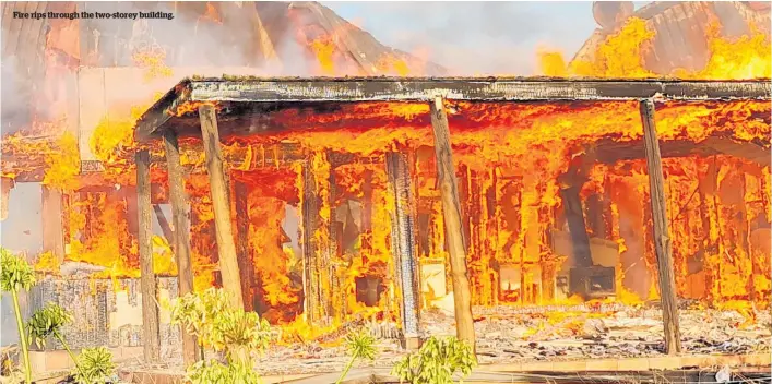  ??  ?? Fire rips through the two-storey building.