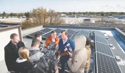  ?? BRANDON HARDER ?? NDP MLA Trent Wotherspoo­n, centre right, told reporters that the net metering program was successful and urged that any new policy be formed with consultati­on from the solar industry. To his left in the orange jacket is fellow NDP MLA Yens Pederson.