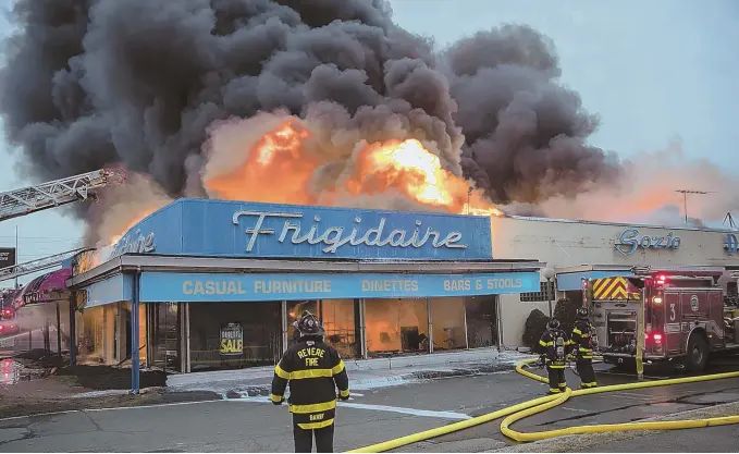  ?? STAFF PHOTOS BY MARK GARFINKEL ?? DARK DAY: A four-alarm fire yesterday afternoon at the Sozio appliance and furniture store in Revere caused up to $1 million in damage, but resulted in no injuries. The cause is being investigat­ed.