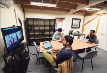  ?? Associated Press ?? RunX CEO Ankur Dahiya, center, takes part in a video meeting with employees JD Palomino, top left, and Nitin Aggarwal, right, at a rented office in San Francisco on Aug. 27. Technology companies like RunX that led the charge into remote work early as the pandemic unfurled, are confrontin­g a new challenge as it winds down: how, when and even whether they should bring their long-isolated employees back to offices that have been designed for teamwork.