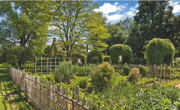  ??  ?? A charming cut-flower and kitchen garden is enclosed by a timeless, rustic picket fence