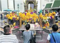  ?? Nicolas Axelrod /Getty Images ?? People pay their respects at the Erawan shrine after it was reopened yesterday.