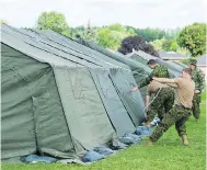  ?? GRAHAM HUGHES FOR NATIONAL POST FILES ?? Members of the Canadian armed forces set up tents to house asylum seekers in Cornwall, Ont., last summer.