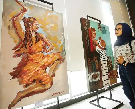  ?? DIMAS MAULANA/JAWA POS ?? GAMBAR PEREMPUAN: Pengunjung melihat salah satu lukisan dalam pameran bertema Ekspresi Rupa kemarin.