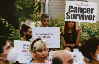  ?? Bilal Hussein / Associated Press ?? Cancer patients hold placards last month during a sit-in at the U.N. headquarte­rs in Beirut to protest shortages of medication­s amid Lebanon's severe economic crisis.