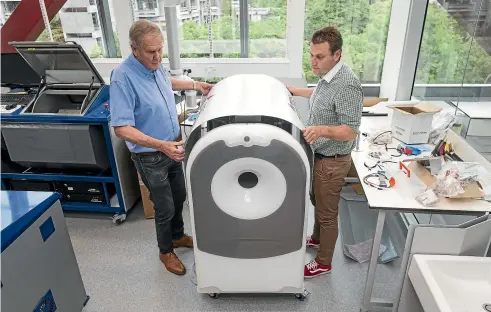  ?? ALDEN WILLIAMS/STUFF ?? Phil, left, and Anthony Butler work on an arm scanner at MARS’ Christchur­ch laboratory.