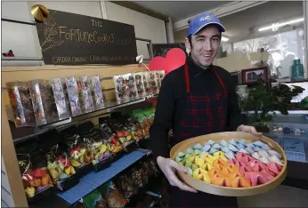  ??  ?? Alex Issvoran displays flavored cookies at the Fortune Cookie Factory on 12th Street near Alice Street in Oakland’s Chinatown. Alicia Wong’s family has owned the factory for over 60years.